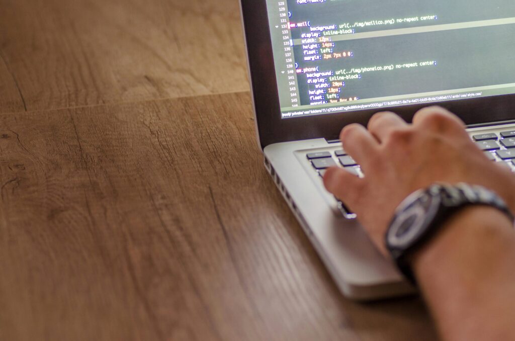 Entwickler analysiert Quellcode zur Website-Fehlerbehebung auf einem Laptop